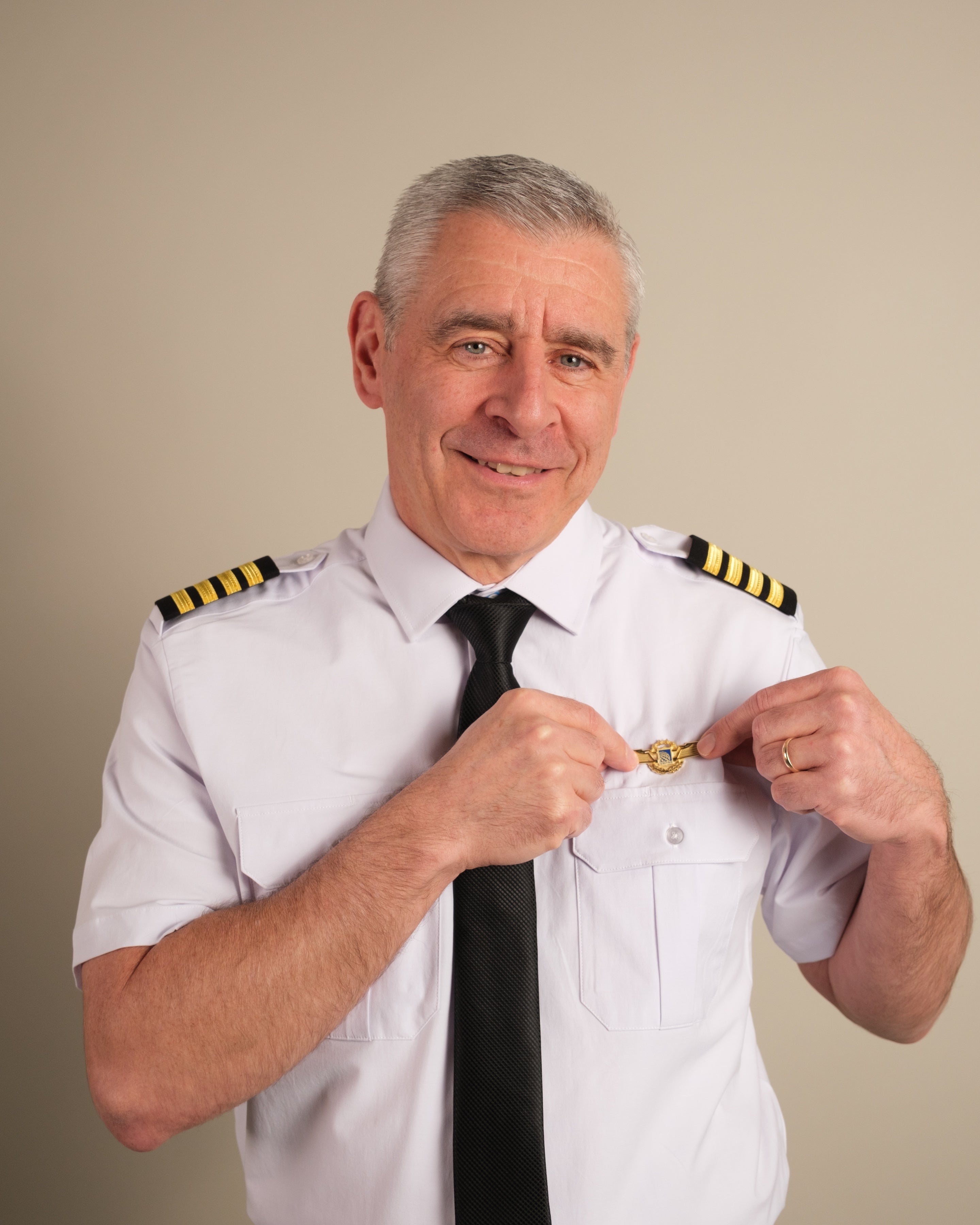 Airline captain pinning gold wings badge onto Cloud Cotton pilot uniform