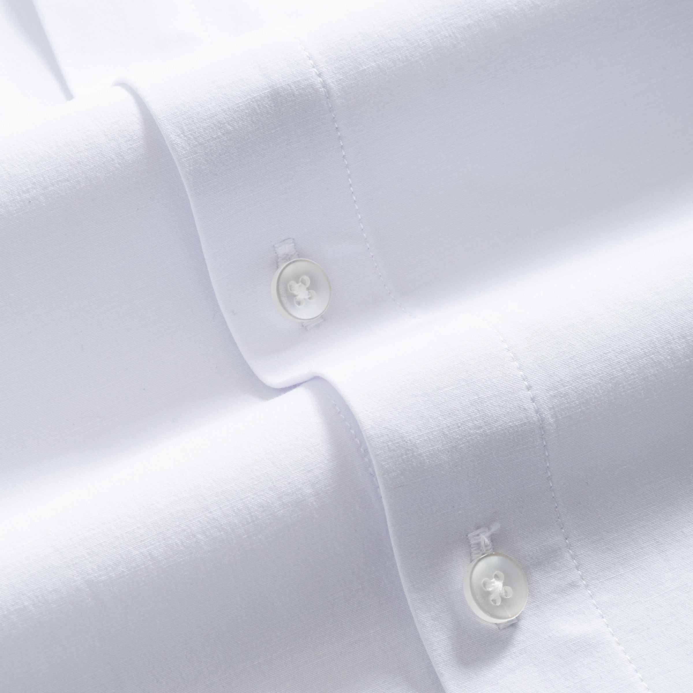 Close-up of white Cloud Cotton pilot shirt fabric and mother-of-pearl button detail